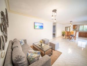 a living room with a couch and a table at Fully Equipped 2br Apt-dt5mins To The Beach in Sosúa