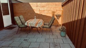 une table et des chaises assises sur une terrasse dans l'établissement Ferienhaus Dittert, à Müritz