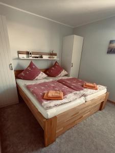 une chambre avec un grand lit avec des oreillers rouges dans l'établissement Ferienhaus Dittert, à Müritz