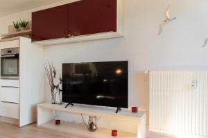 un salon avec une grande télévision à écran plat sur un mur dans l'établissement Ferienwohnung Ostseerauschen 2, à Scharbeutz