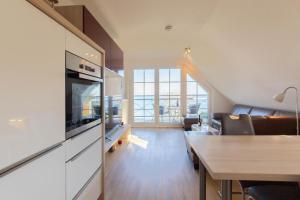 un salon avec une cuisine et une salle à manger dans l'établissement Ferienwohnung Ostseerauschen 2, à Scharbeutz