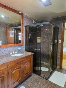 a bathroom with a shower and a sink at Hotel Negreiros in São Lourenço