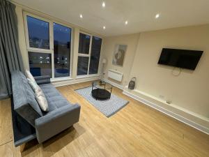 a living room with a couch and a flat screen tv at Newcastle Executive Stays in Newcastle upon Tyne