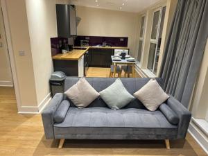 a couch in a living room with a kitchen at Newcastle Executive Stays in Newcastle upon Tyne +30 photos