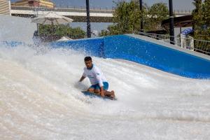 a young man riding a wave ride on a water slide at Grand Hyatt Dubai Resort & Waterpark in Dubai