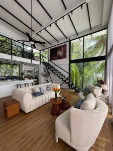 贡布Daya Villa的客厅里有两张白色沙发和一座楼梯