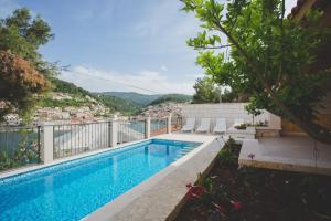 a swimming pool on the balcony of a house at Apartments and rooms with a swimming pool Pucisca, Brac - 5637 in Pučišća
