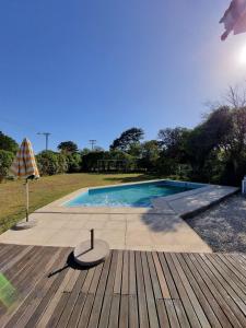 einen Pool mit einem Tisch und einem Sonnenschirm in der Unterkunft Casa La Emiliana Playa Chapadmalal in La Estafeta