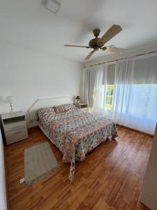 ein Schlafzimmer mit einem Bett und einem Deckenventilator in der Unterkunft Casa La Emiliana Playa Chapadmalal in La Estafeta