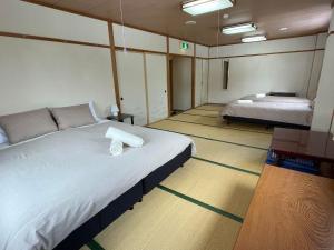 a bedroom with a large bed and two beds sidx sidx sidx at Sanso On Snow in Nagano