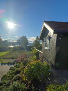 a house with a garden with the sun in the background at Lovely tiny house with a dream view !  +22 photos