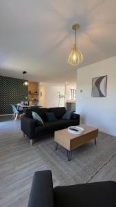 a living room with a black couch and a table at La maison d a cote in Éguzon-Chantôme