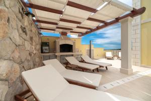 eine Terrasse mit weißen Möbeln und einer Steinmauer in der Unterkunft Holiday house with a swimming pool Prizba, Korcula - 199 in Prizba