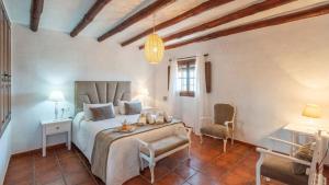 ein Schlafzimmer mit einem Bett, einem Tisch und einem Stuhl in der Unterkunft Casa El Carril Benalauria by Ruralidays in Benalauría + 26 Fotos