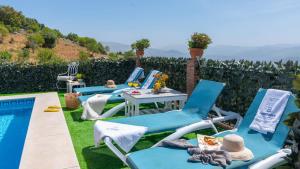 eine Gruppe blauer Stühle neben einem Pool in der Unterkunft Casa El Carril Benalauria by Ruralidays in Benalauría