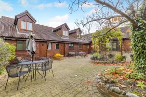 Un patio con una mesa y sillas frente a una casa. en 2 Bed in Smallburgh oc-h33734, en Dilham