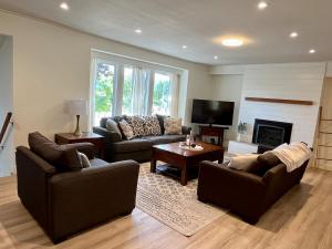 ein Wohnzimmer mit zwei Sofas und einem Kamin in der Unterkunft Camelia Home in Kelowna