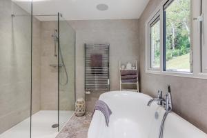a bathroom with a tub and a glass shower at 4 Bed in Aberdovey oc-p33131 in Scyborycoed +22 photos