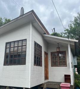 a white house with a brown door at Cabañas Sofía in Puerto Cisnes