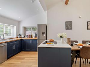 a large kitchen with blue cabinets and a table at 2 Bed in Leppington 96260 in Acklam