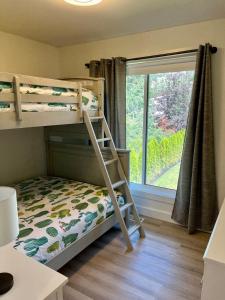 Etagenbett in einem Zimmer mit Fenster in der Unterkunft Camelia Home in Kelowna