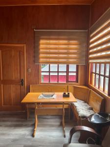 a dining room with a wooden table and a window at Cabañas Sofía in Puerto Cisnes
