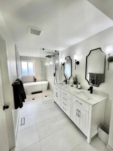 ein weißes Badezimmer mit 2 Waschbecken und einer Badewanne in der Unterkunft Camelia Home in Kelowna + 20 Fotos