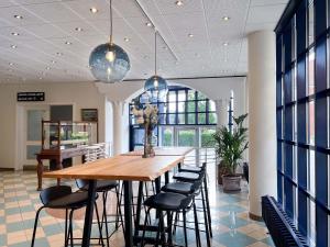 a dining room with a wooden table and chairs at Hotel Frederikshavn in Frederikshavn