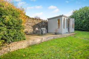 a small shed in a yard next to a stone wall at 1 Bed in Uldale oc-g34032 in Uldale