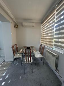une table et des chaises dans une pièce avec une fenêtre dans l'établissement Registan 15 min walk away, à Samarcande