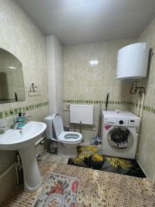 une salle de bain avec un lavabo et une machine à laver dans l'établissement Registan 15 min walk away, à Samarcande