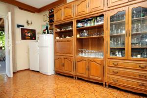 eine Küche mit Holzschränken und einem Kühlschrank in der Unterkunft Apartments and rooms by the sea Vrboska (Hvar) - 540 in Vrboska
