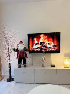 a santa claus statue standing in front of a tv at Sara Apartament in Turek