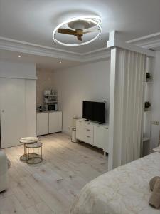 Un dormitorio blanco con una cama y un ventilador de techo. en Loft Casco Antiguo, en Pamplona