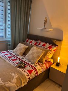 a bed in a bedroom with a candle on it at Sara Apartament in Turek