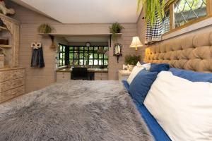 a bedroom with a large bed with blue and white pillows at The Tree Cabins Quinta Pavo Real by AcoModo in San José