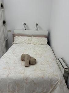 Una cama blanca con una toalla. en Loft Casco Antiguo, en Pamplona