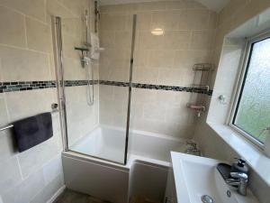 a bathroom with a shower and a tub and a sink at Modern-privateGarden-Family-20MinToLDN in Stevenage +13 photos