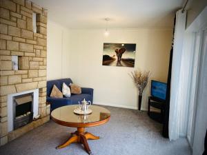 a living room with a blue couch and a table at Modern-privateGarden-Family-20MinToLDN in Stevenage