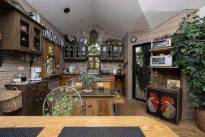 a large kitchen with wooden cabinets and a table at The Tree Cabins Quinta Pavo Real by AcoModo in San José