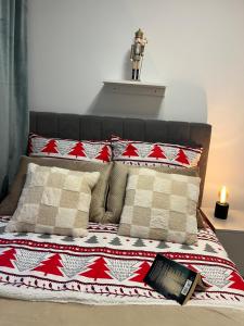 a bed with a red and white blanket and pillows at Sara Apartament in Turek