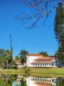 a building with a pond in front of it at Hotel Negreiros in São Lourenço