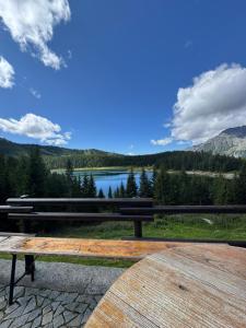 a wooden bench sitting on a table overlooking a lake at La Casetta del Picchio in Caspoggio