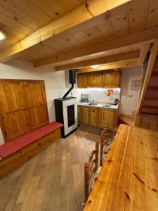a kitchen with wooden cabinets and a table and a stove at La Casetta del Picchio in Caspoggio