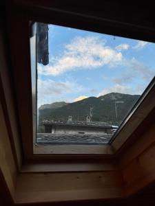 a window in a room with a view of a mountain at La Casetta del Picchio in Caspoggio +4 photos