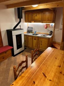 a kitchen with a wooden table and a stove at La Casetta del Picchio in Caspoggio +4 photos