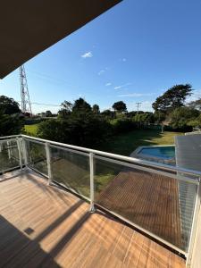 ein Balkon mit Terrasse und Blick auf einen Pool in der Unterkunft Casa La Emiliana Playa Chapadmalal in La Estafeta + 7 Fotos