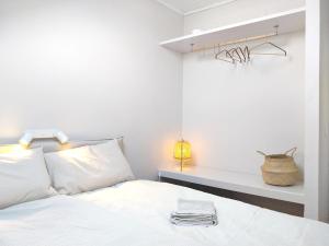 a white bedroom with a bed and a shelf at Old Town Apt with Ocean Views in Sesimbra +12 photos