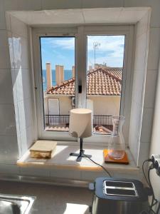 a window with a vase on a table in a room at Old Town Apt with Ocean Views in Sesimbra
