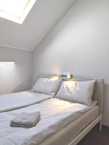 a bed with white sheets and pillows in a room at Old Town Apt with Ocean Views in Sesimbra